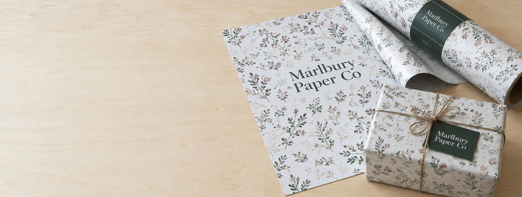 Custom printed wrapping paper sheets and rolls with logo on a studio table